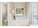 Serene bathroom featuring a soaking tub with views of the private backyard at 19275 N 88Th Way, Scottsdale, AZ 85255