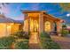 Inviting front entrance with stone pathway, lush landscaping, large arched windows, and decorative iron door detail at 19275 N 88Th Way, Scottsdale, AZ 85255