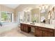 Well-lit main bathroom featuring dual sinks, ample counter space, a soaking tub, and a separate glass-enclosed shower at 19275 N 88Th Way, Scottsdale, AZ 85255