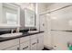 Bathroom featuring double sinks with white cabinetry and a glass-enclosed shower at 2391 S 171St Ln, Goodyear, AZ 85338