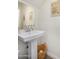 Bright powder room featuring a pedestal sink, large mirror, and tasteful decor at 2494 N Heritage St, Buckeye, AZ 85396