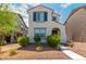 Charming two-story home featuring a light-colored facade, red tile roof, and blue shutters on the upper window at 2494 N Heritage St, Buckeye, AZ 85396