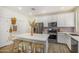 Stylish kitchen showcasing white cabinets, stainless steel appliances, and a center island with seating at 2494 N Heritage St, Buckeye, AZ 85396