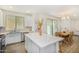 Bright kitchen with white cabinetry, stainless steel appliances, and a center island, flowing into the dining area at 2494 N Heritage St, Buckeye, AZ 85396