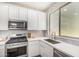Modern kitchen with white cabinets, stainless steel appliances, and a large window over the sink at 2494 N Heritage St, Buckeye, AZ 85396