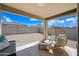 Relaxing covered patio with comfortable seating and a spacious backyard featuring low-maintenance desert landscaping at 25657 W Beth Dr, Buckeye, AZ 85326