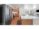 Bright kitchen with wood cabinets, stainless steel appliances, and an island overlooking the living space at 25657 W Beth Dr, Buckeye, AZ 85326
