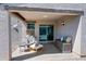A cozy covered patio features a wicker chair, coffee table and additional seating with stylish pillows at 25657 W Beth Dr, Buckeye, AZ 85326