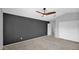 Empty bedroom with neutral carpet, a dark accent wall, a ceiling fan, and a view to the entry and closet at 28021 N 23Rd Dr, Phoenix, AZ 85085
