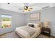 Cozy bedroom featuring a ceiling fan, neutral decor, and a bright window view at 28021 N 23Rd Dr, Phoenix, AZ 85085