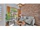 Inviting living room with a rustic brick wall, arched windows, and stylish decor at 28021 N 23Rd Dr, Phoenix, AZ 85085