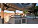 Outdoor kitchen featuring built-in grill, sink, and storage, all under a pergola overlooking the pool and mountain views at 28021 N 23Rd Dr, Phoenix, AZ 85085