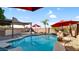 Beautiful pool with waterfall feature, red umbrellas, and outdoor kitchen and pergola providing a perfect backyard oasis at 28021 N 23Rd Dr, Phoenix, AZ 85085