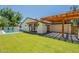 Expansive backyard with a pergola-covered patio, lush lawn, and a sparkling swimming pool at 3651 N 49Th Pl, Phoenix, AZ 85018