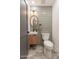 Stylish powder room with a unique tile backsplash, stone floors, and a wood framed mirror at 3651 N 49Th Pl, Phoenix, AZ 85018