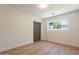 Clean bedroom, wood-look floors, neutral paint, large window, dark gray closet doors at 3651 N 49Th Pl, Phoenix, AZ 85018