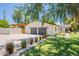 This home features a bright white exterior with a two-car garage and beautiful landscaping and mature shade trees at 3651 N 49Th Pl, Phoenix, AZ 85018