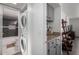 A laundry area features a stacked washer and dryer and adjoins a bathroom with tiled walls at 4150 E Cactus Rd # 205, Phoenix, AZ 85032