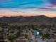 Wide aerial view of residential area with mountain backdrop and colorful sunset sky at 4252 E Zia St, Phoenix, AZ 85044