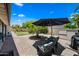 Landscaped backyard featuring a patio area with outdoor seating under a large shade umbrella at 4252 E Zia St, Phoenix, AZ 85044