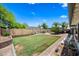 Large backyard with a well-maintained lawn, brick accents, and mature trees, creating a serene outdoor oasis at 4252 E Zia St, Phoenix, AZ 85044