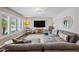 Bright living room showcases hardwood floors, large windows with shutters, and a cozy gray sectional couch at 4252 E Zia St, Phoenix, AZ 85044