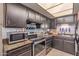 Functional kitchen featuring stainless steel appliances and dark wooden cabinets at 4814 W Rose Ln, Glendale, AZ 85301
