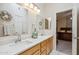 Bathroom with double sink vanity, decorative mirrors and wreath with doorway view to bedroom at 4918 W Wahalla Ln, Glendale, AZ 85308