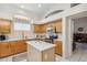 Well-lit kitchen with stainless steel appliances, an island, white countertops, and wood cabinets at 4918 W Wahalla Ln, Glendale, AZ 85308