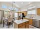Bright kitchen with an island, stainless steel appliances, wood cabinets, tile floors and natural light at 4918 W Wahalla Ln, Glendale, AZ 85308