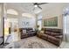 Spacious living room boasts a ceiling fan, tile flooring, leather furniture and bright natural light at 4918 W Wahalla Ln, Glendale, AZ 85308