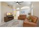 Comfortable living room with tile floor, a wooden TV stand, and dual leather sofas at 4918 W Wahalla Ln, Glendale, AZ 85308