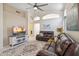 Comfortable living room featuring leather furniture, ceiling fan, tiled floors, and decorative arched elements at 4918 W Wahalla Ln, Glendale, AZ 85308