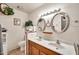 Bathroom featuring wood cabinets, double sinks, and framed mirrors, with plants around the room at 5140 N 69Th Ave, Glendale, AZ 85303