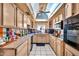 Bright kitchen featuring white tile floor, vintage cabinets and countertops, and skylight at 5140 N 69Th Ave, Glendale, AZ 85303