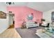 Bright living room with a pink accent wall, tile and carpet flooring and comfortable seating at 5140 N 69Th Ave, Glendale, AZ 85303