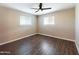 Bedroom featuring laminated wood floors, ceiling fan, light-colored walls and two windows at 5414 E Albany St, Mesa, AZ 85205