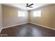 Bedroom with laminated wood floors, ceiling fan, light-colored walls and a large window at 5414 E Albany St, Mesa, AZ 85205