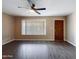 Comfortable living room with laminated wood floors, ceiling fan, light-colored walls and a large window at 5414 E Albany St, Mesa, AZ 85205