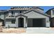 New two-story home features a gray stucco exterior, arched entryway, two car garage, and a stacked tile roof at 5439 S 251St Dr, Buckeye, AZ 85326