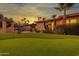 Beautiful backyard featuring a putting green, pool, palm trees, patio, and a colorful sunset at 6043 E Hearn Rd, Scottsdale, AZ 85254