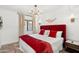 Bedroom with a vibrant red comforter, decorative wall art, and bedside table at 6043 E Hearn Rd, Scottsdale, AZ 85254