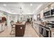 Open kitchen with stainless steel appliances, center island, fireplace, and cozy view into living area at 6043 E Hearn Rd, Scottsdale, AZ 85254