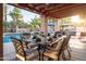 Inviting covered patio with a dining table and a view of the sparkling pool and manicured backyard, perfect for outdoor entertaining at 6043 E Hearn Rd, Scottsdale, AZ 85254
