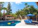 Relaxing backyard oasis featuring a refreshing pool, comfortable lounge chairs, mature trees, and a charming water fountain at 6043 E Hearn Rd, Scottsdale, AZ 85254
