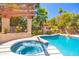 Inviting pool and spa area with a stone surround and tropical landscaping at 6043 E Hearn Rd, Scottsdale, AZ 85254