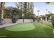 Lush putting green surrounded by mature trees and manicured landscaping at 6043 E Hearn Rd, Scottsdale, AZ 85254