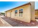 Beige home exterior with security door, 2 windows, and attractive rock landscaping and a blue sky at 619 E Jensen St # 14, Mesa, AZ 85203