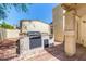 Outdoor grill on a brick patio with blue sky and stucco columns with view of adjacent building at 619 E Jensen St # 14, Mesa, AZ 85203