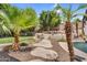 A serene backyard featuring a stone pathway, tiered garden, and lush tropical landscaping at 6352 W Hackamore Dr, Phoenix, AZ 85083